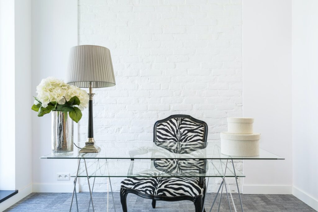 Office with glass desk and zebra armchair